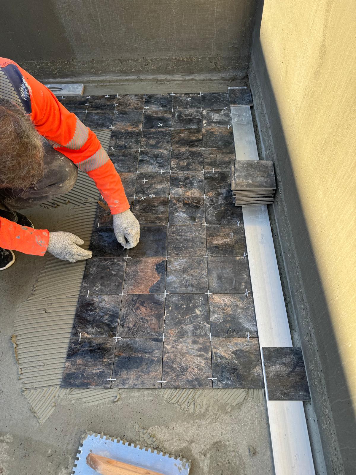 Pose précise du carrelage marbre avec croisillons et règle de niveau
