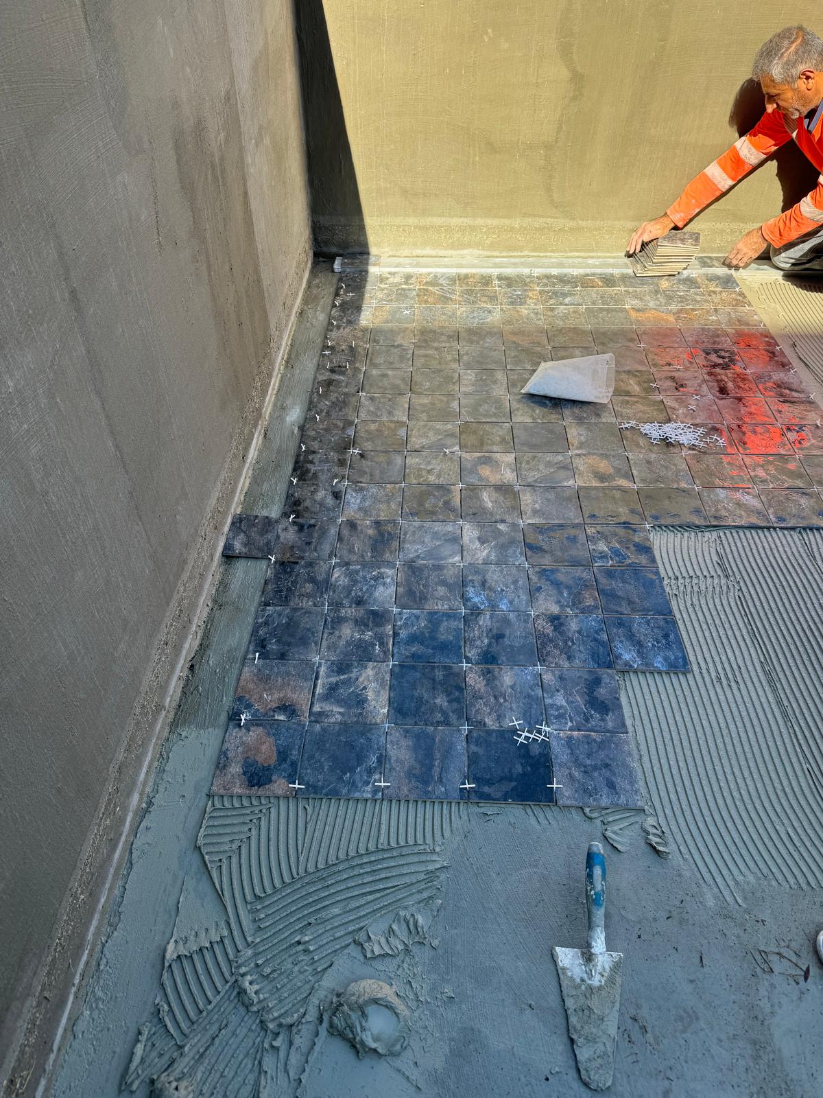 Carrelage piscine en cours de pose, fond du bassin progressant